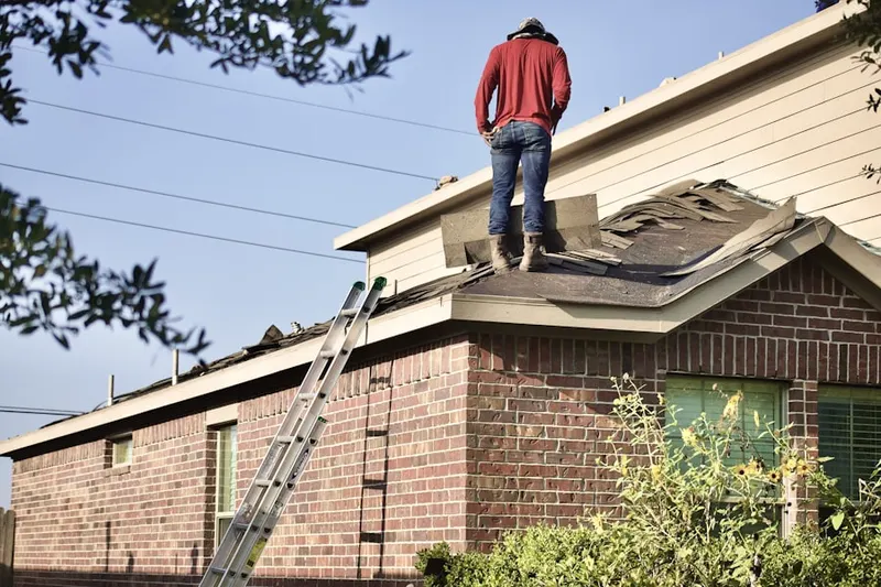 Professional roofer working on a residential roof in Cedarhurst